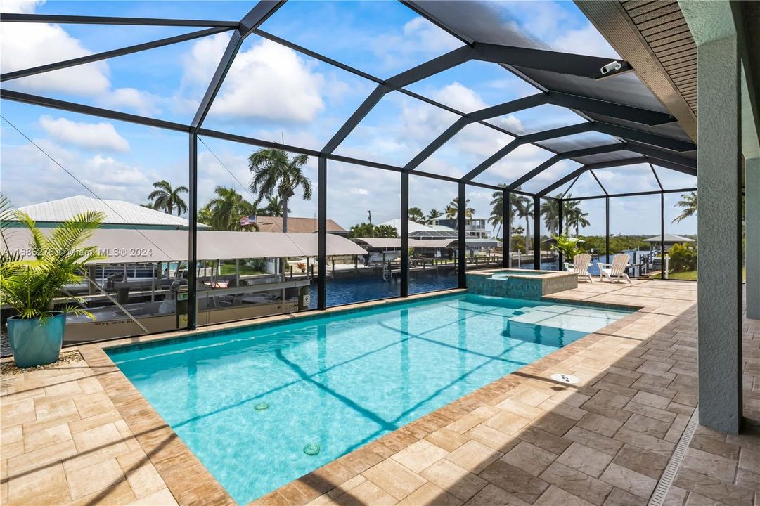 Full length photo of the pool, spa, outdoor patio and the covered boat lift! Why this house? It checks all the boxes - a private and quiet culdesac location, stunning newer home, all the bells and whistles, and the water access is second to none!