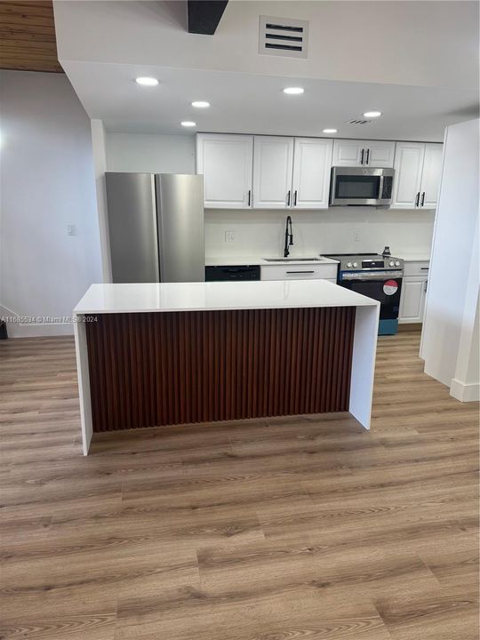 island counter with waterfall quartz & beautiful wood struts design