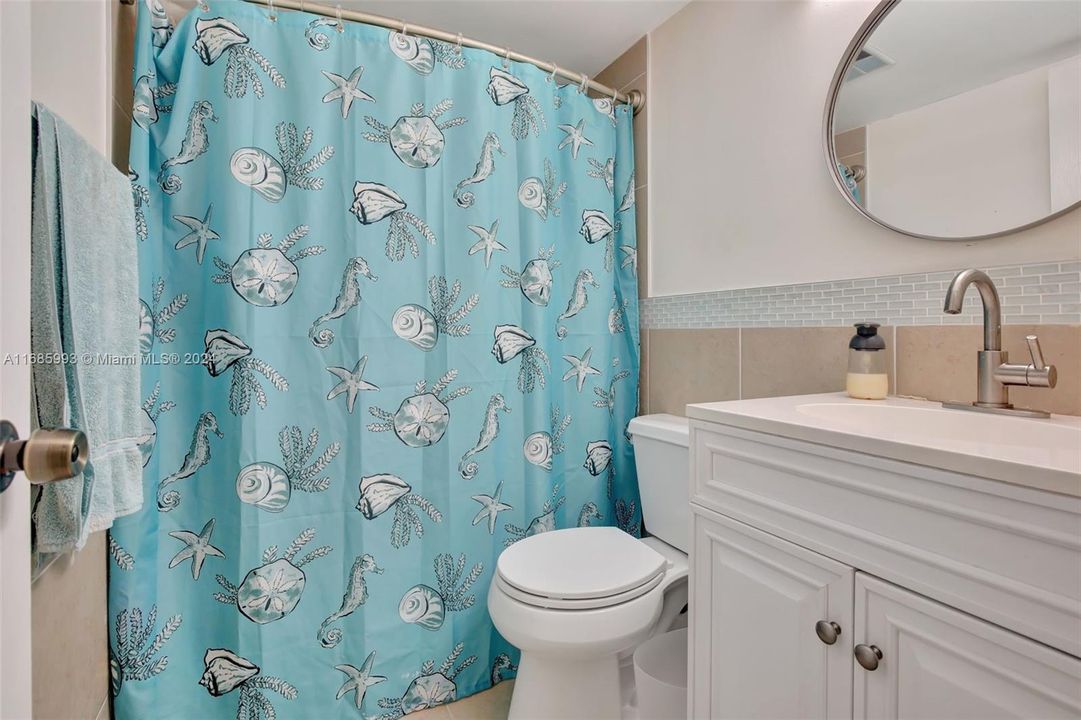 Bathroom 2. Updated tiles, vanity, mirror, and fixtures.