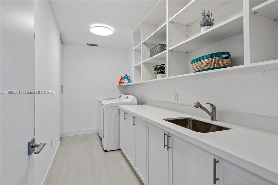 Modern and spacious laundry room with sleek cabinetry and quartz countertop