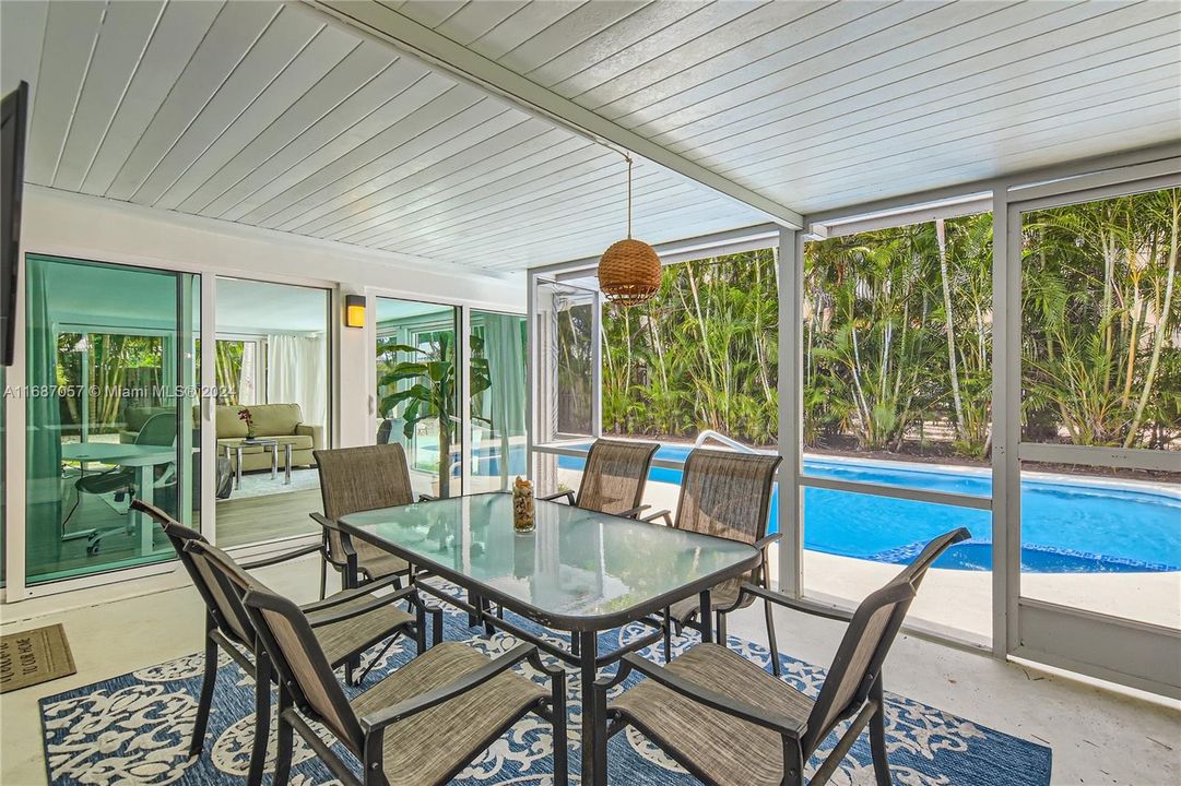 Enclosed screen area for dinning overlooking the pool and patio