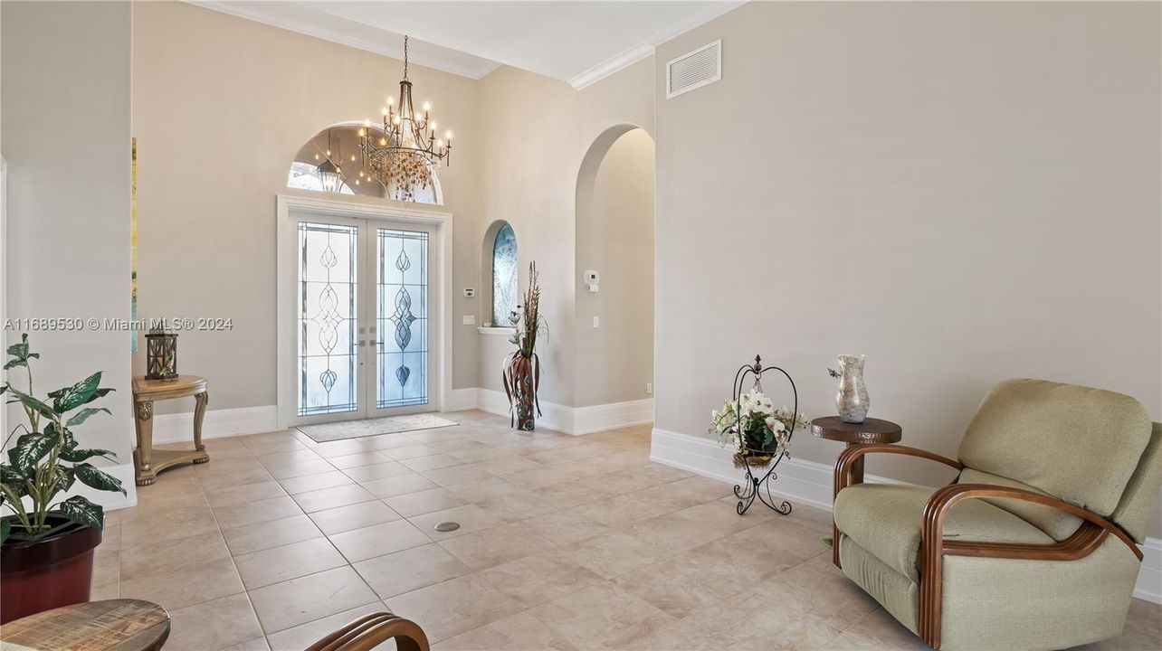 Double door foyer welcomes you into this additional living space that looks out onto the patio. More beautiful designer shades, and electrical floor outlet with plenty of space.