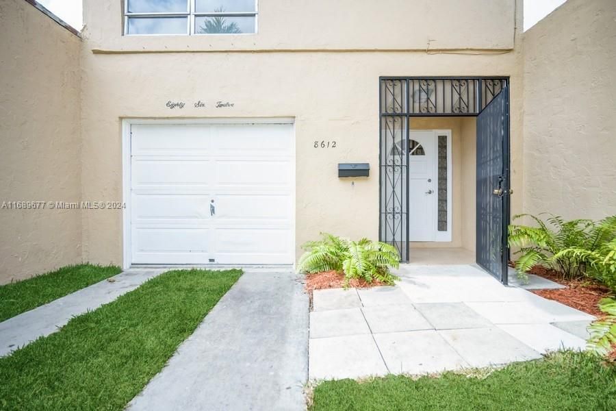 Some nice plants are planted along the right wall and you have a security gate in front of the front door!