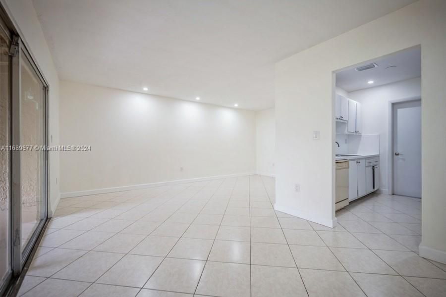 This picture shows the sliding glass doors on the left and Diningroom/Familyroom & kitchen on the right! Notice the recessed lights in the ceiling in all the pictures? The floors are a nice off-bege tile.