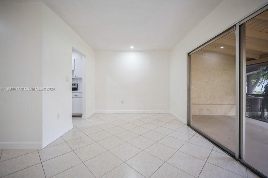 The sliding glass doors open to the screened patio on the right and you can see the entrance to the kitchen on the left.