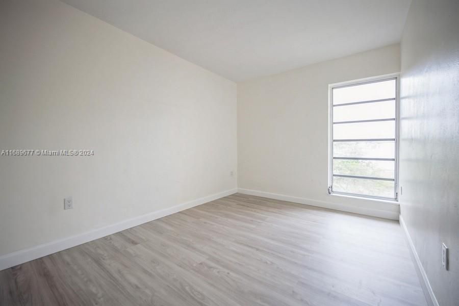 SW Bedroom with new laminated wood flooring as well as the Primary Bedroom and the staircase!