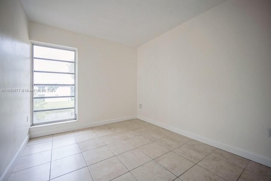 This is NW Bedroom looking out the large window with it's tile flooring.