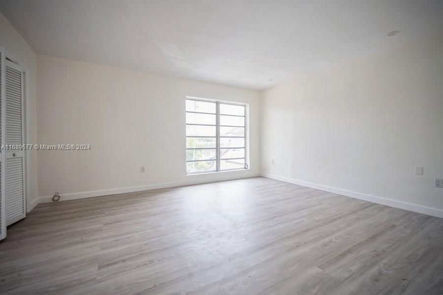 Look at the new laminated wood floors and the dbl Bank of windows facing East. There are 2 sets of closets in the primary bedroom. There is a recessed light in the ceiling.