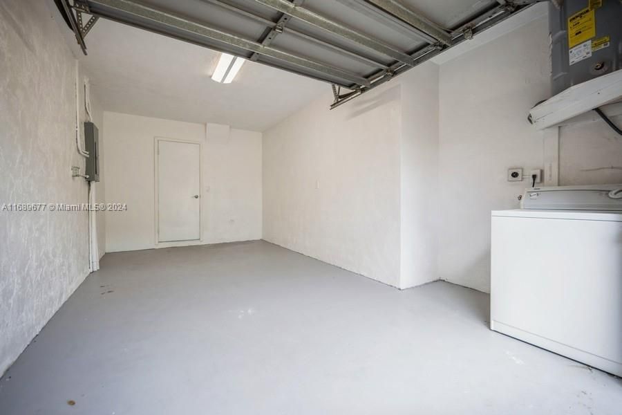 Here is the 1Car garage with space for the washer/dryer on the right. The kitchen door can be seen in the middle of the picture! The garage has a brand new electrical panel on the left wall. Above the dryer you can see the brand new Hot Water Heater that is off the floor so your car can fit in the garage.