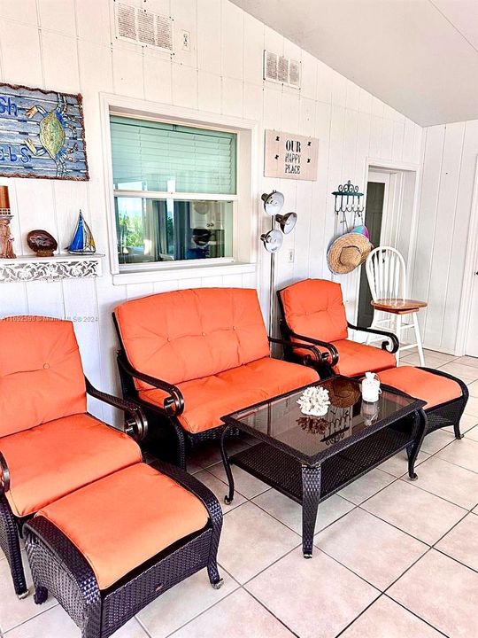 Florida room- kitchen window behind chairs