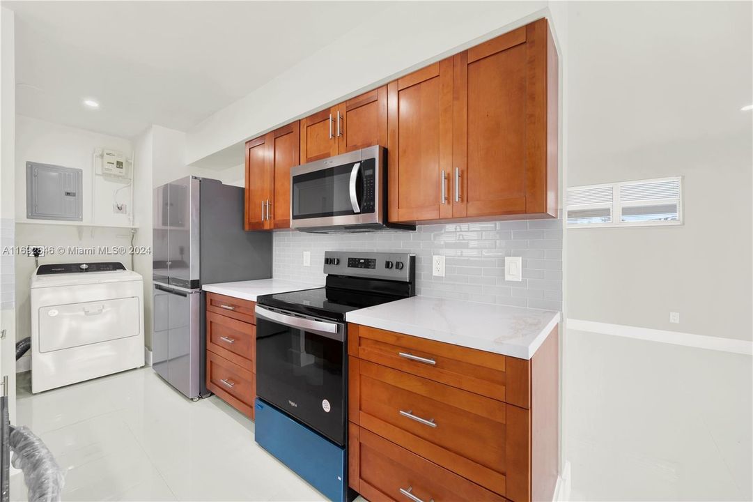 Renovated kitchen, and quartz counter tops with subway tiled backsplash.