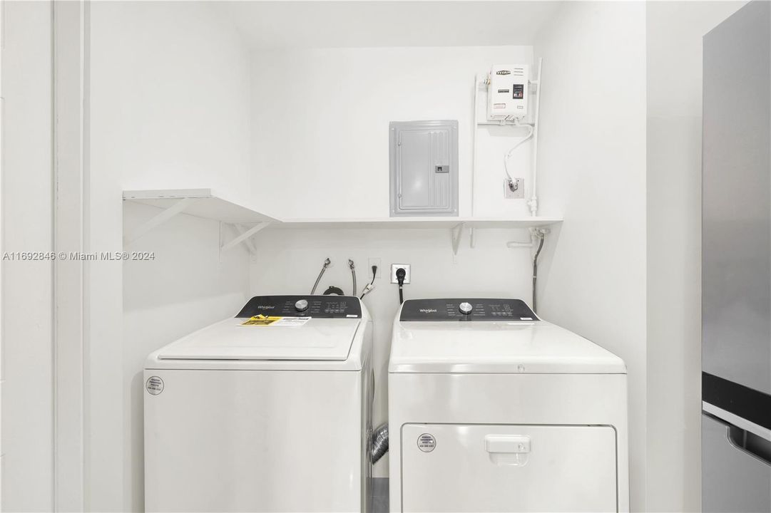 Laundry room off the kitchen with side door access to the outside. New tankless water heater