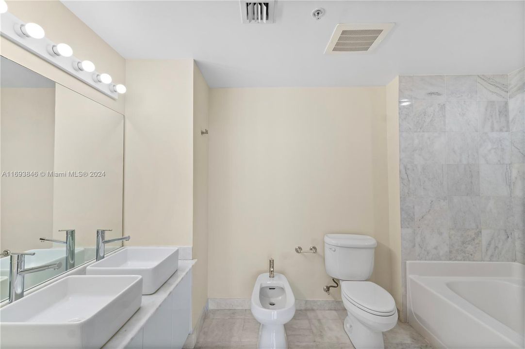 Master bathroom with dual sinks, bidet, and shower/tub