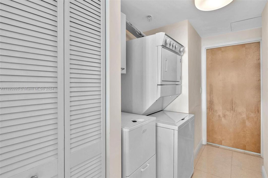 LARGE LAUNDRY ROOM WITH DOOR LEADING TO SERVICE HALLWAY