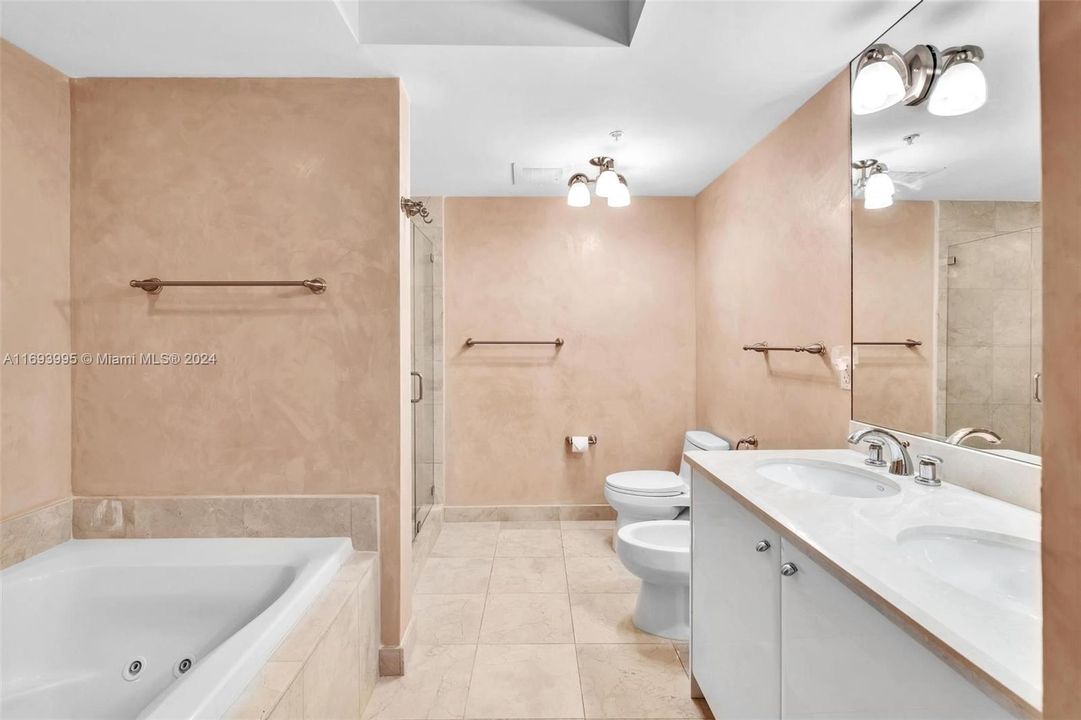 PRIMARY MARBLE BATH IS ENSUITE AND FEATURES A JACUZZI TUB AND SEPARATE ENCLOSED SHOWER, TWO SINKS AND BIDET!