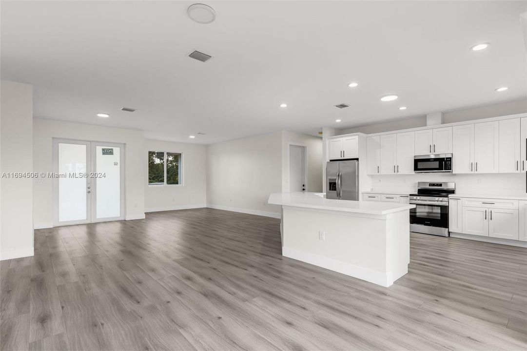 CUSTOM KITCHEN W/ CENTER ISLAND OVERLOOKING THE OPEN FLOOR PLAN LIVING ROOM.