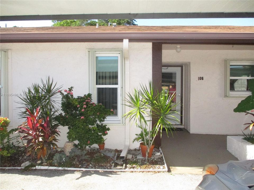 ENTRANCE INTO THE VILLA WITH CARPORT PARKING IN FRONT