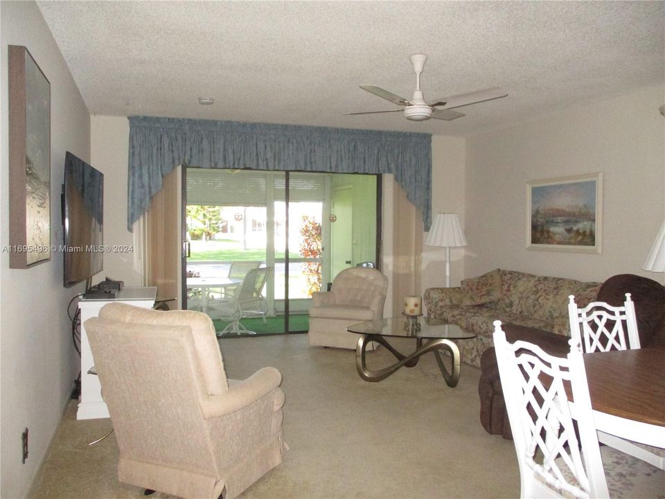 OPEN LIVING/DINING AREA WITH SLIDING DOOR TO SCREENED PATIO