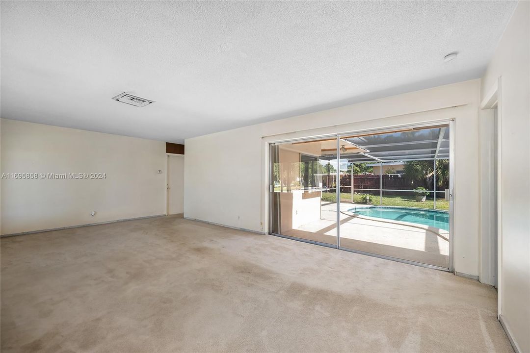 Combined Living and Dining Room with view of pool