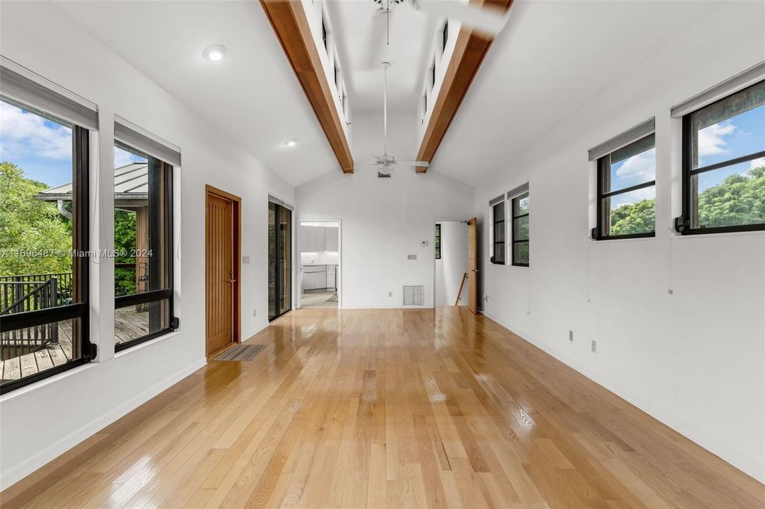 FRONT  DOOR ENTRANCE TO THE LIVING ROOM W/ CUPOLA STYLE CEILING, WOOD FLOORS, SURROUNDED BY WINDOWS, FEELS LIKE YOU ARE LIVING IN A TREE HOUSE.