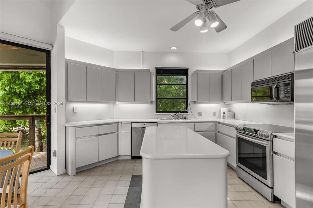 MODERN LARGE KITCHEN WITH TONS OF STORAGE, UP LIGHTING, CENTER ISLAND, STAINLESS STEEL APPLIANCES.