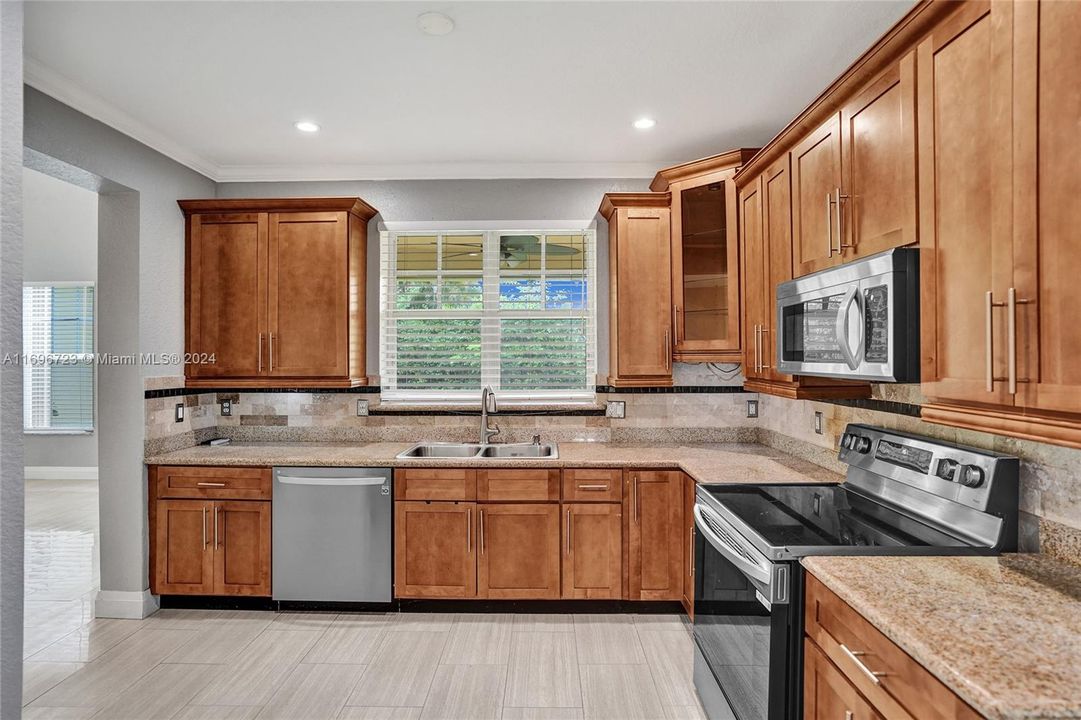 Crown molding accented wood cabinets with tiled and granite workspace areas!