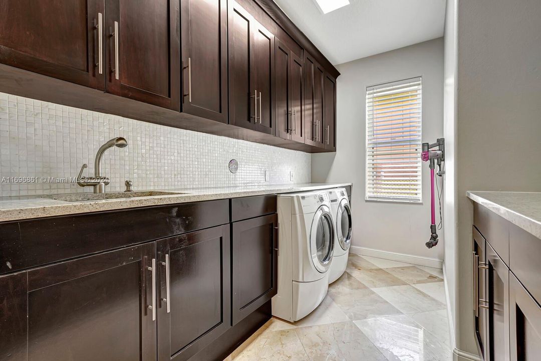 Laundry Room with cabinets and quartzite counters