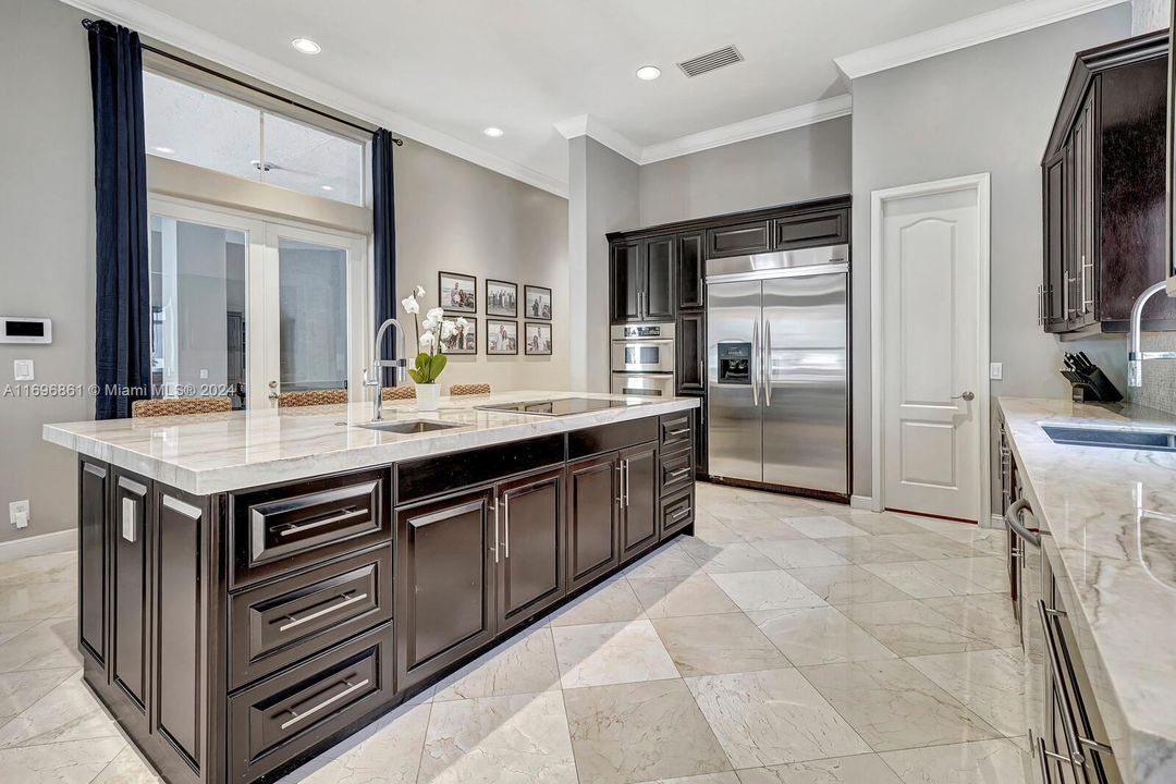 Kitchen quartzite island with cook top range and extra sink.