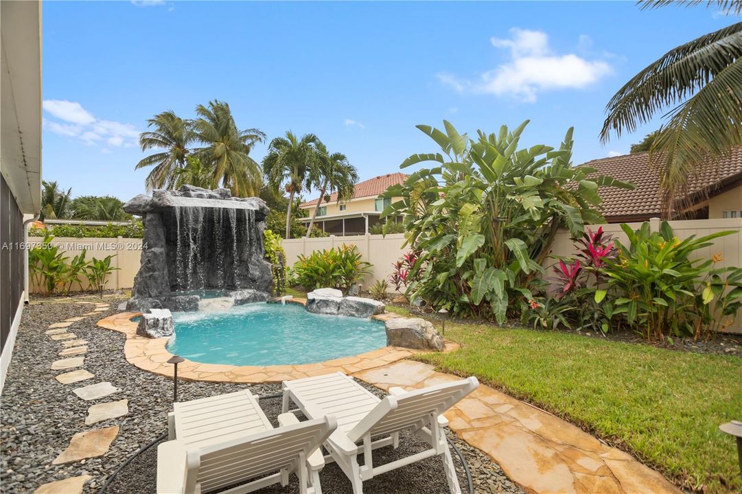 heated pool and hot tub. with waterfall grotto, tiki covered outdoor kitchen and Firepit area