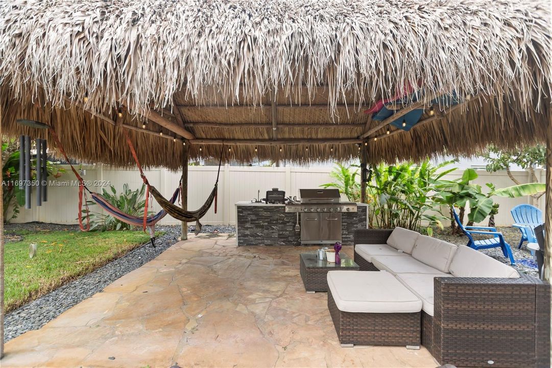 heated pool and hot tub. with waterfall grotto, tiki covered outdoor kitchen and Firepit area