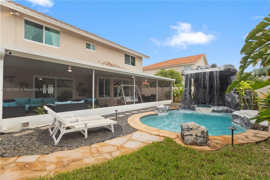 heated pool and hot tub. with waterfall grotto, tiki covered outdoor kitchen and Firepit area