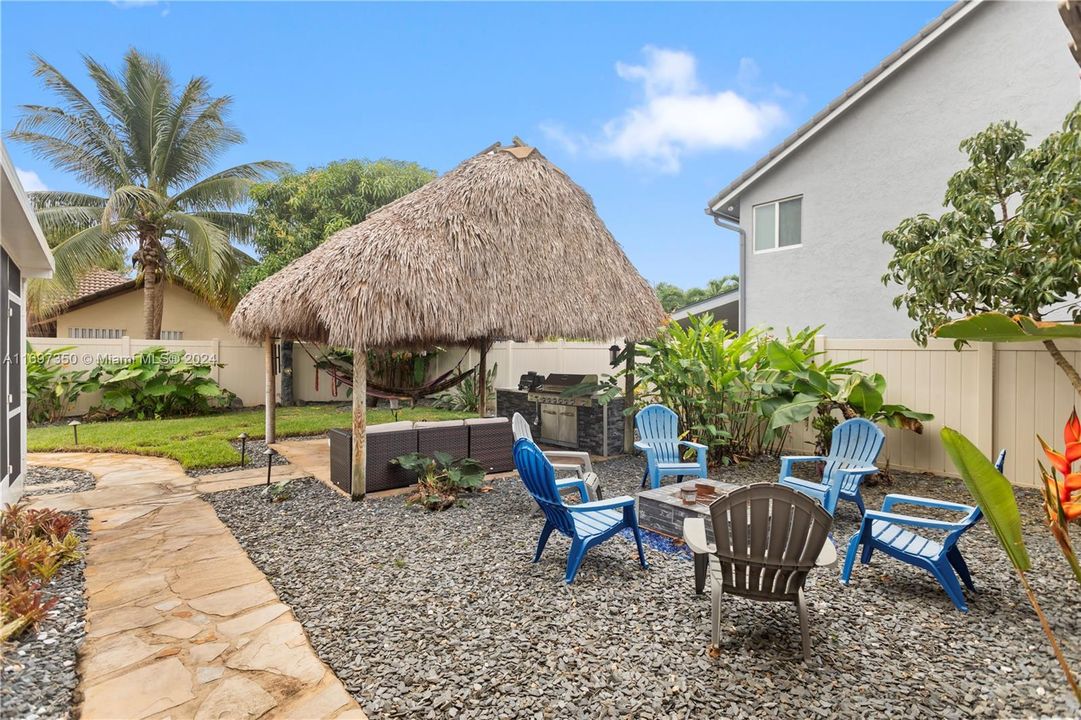 heated pool and hot tub. with waterfall grotto, tiki covered outdoor kitchen and Firepit area