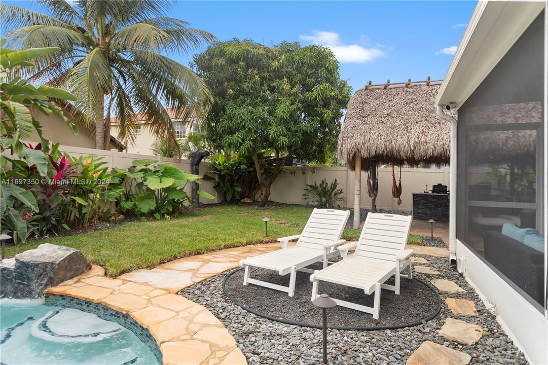 heated pool and hot tub. with waterfall grotto, tiki covered outdoor kitchen and Firepit area