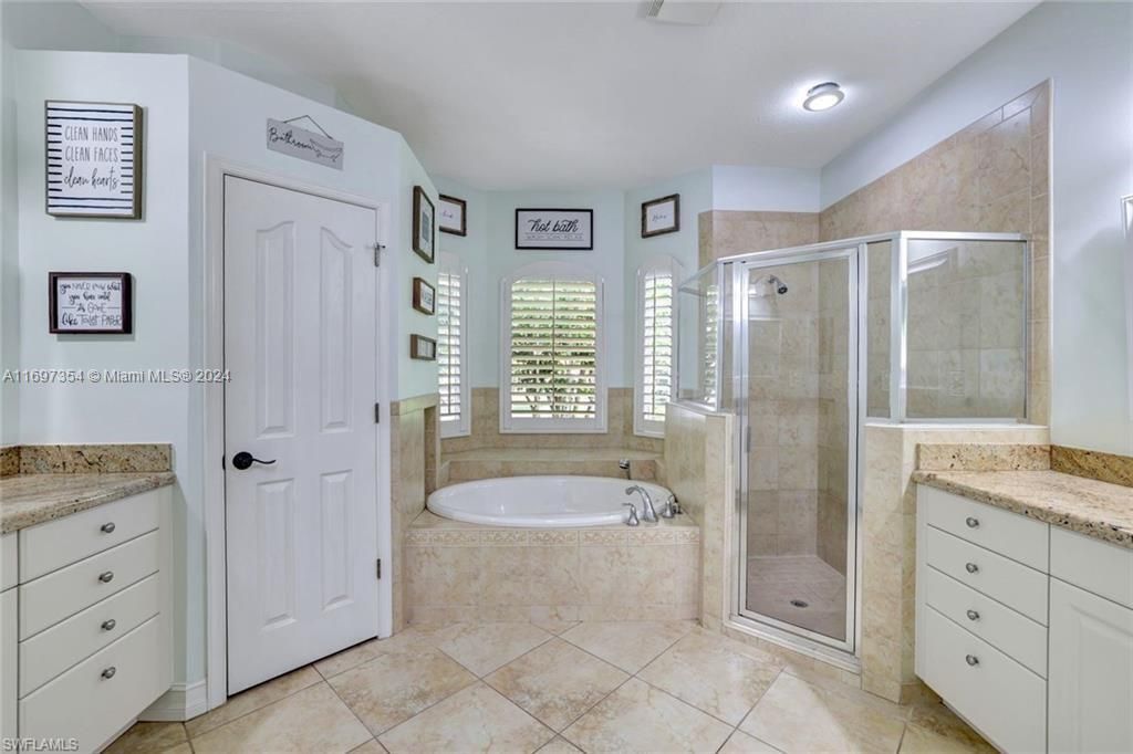 Bathroom with vanity, plus walk in shower, and tile patterned flooring