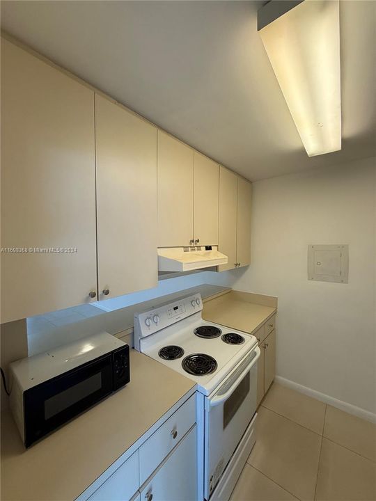 Kitchen includes microwave, electric range and oven, refrigerator.