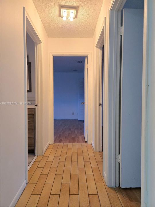 Hallway to 3 bedrooms and bathroom