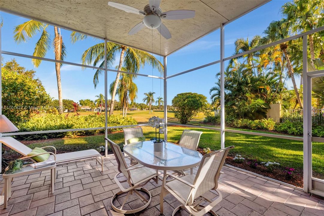 Covered / screened patio w/ brick pavers and fan overlooks golf & water