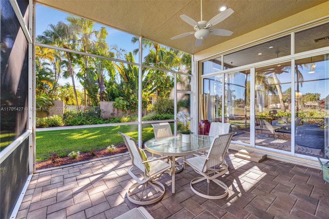 Covered / screened patio w/ brick pavers and fan overlooks golf & water