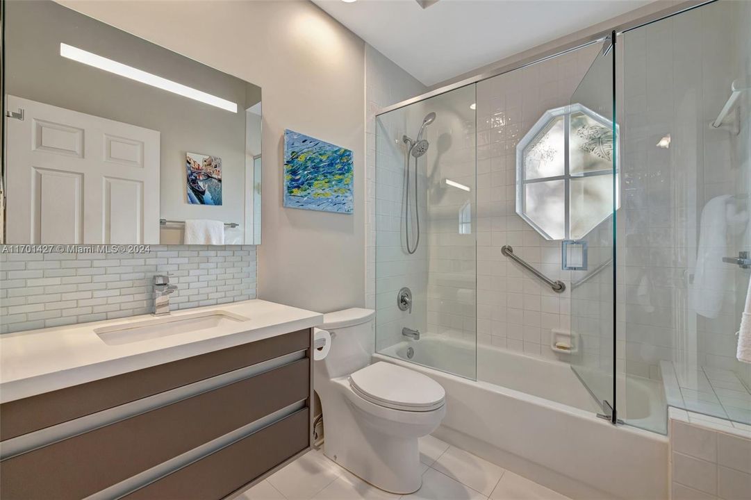 En Suite Guest Bathroom w/ Floating Vanity, Porcelain Floor, combo tub/ shower