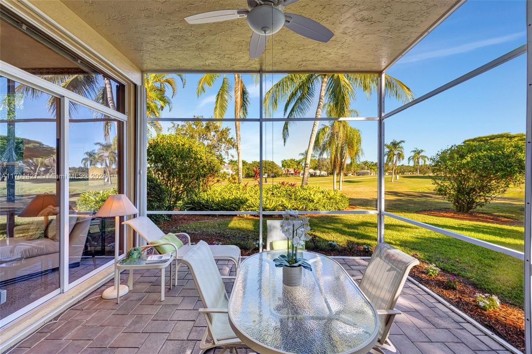 Covered / screened patio w/ brick pavers and fan overlooks golf & water