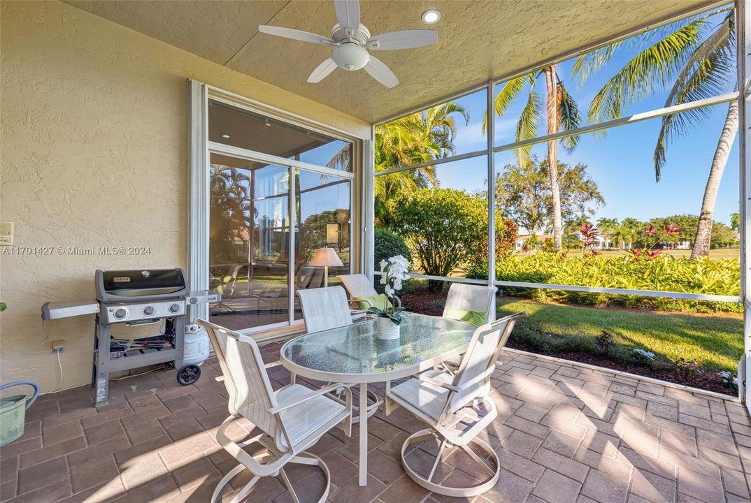 Covered / screened patio w/ brick pavers and fan overlooks golf & water