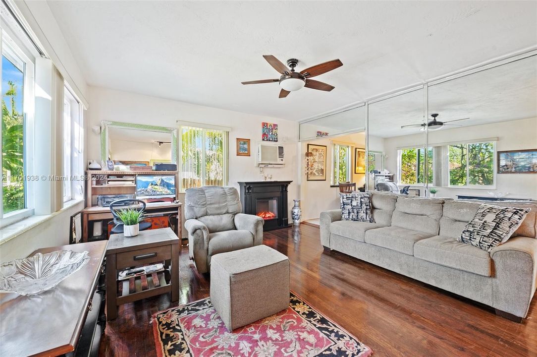 Bright living area with beautiful original wood floors. Impact windows.