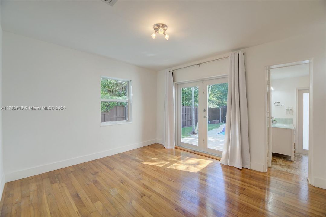 Primary Bedroom with impact double door access to the patio/outdoor area + Impact Windows+  Ensuite Primary/Cabana Bathroom