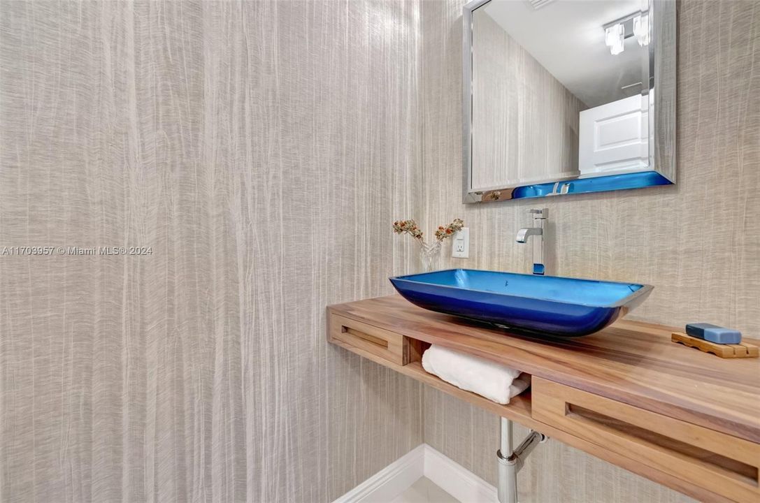 Custom powder room w/ walnut wall hung vanity and vessel sink, custom wallpaper (porcelain flooring)