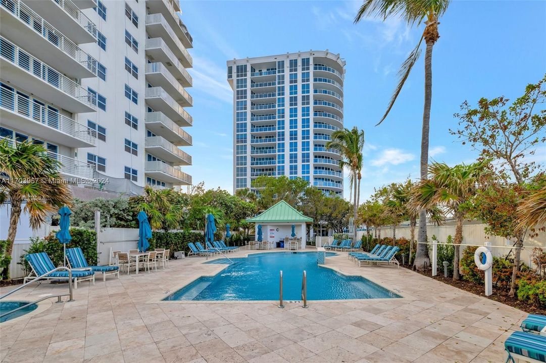 View toward building behind the pool area. Plenty of seating and umbrellas. Heated Pool, recently upgraded pool area