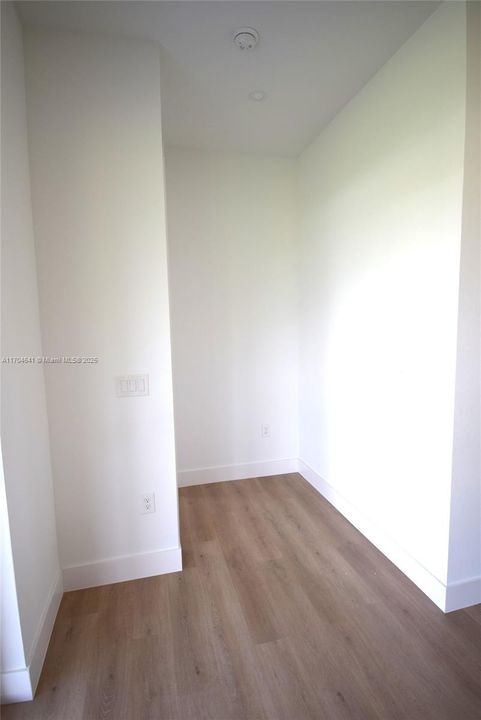 Hall from primary bedroom to primary bathroom, with walk-in closets.