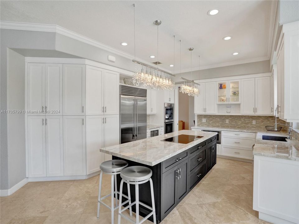 Gourmet kitchen features dual toned cabinetry, gorgeous quartzite counter