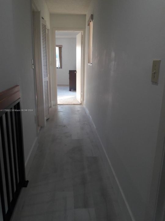 UPSTAIRS HALLWAY W/LAMINATE FLOORING LEADING TO BATHROOM AND ROOMS