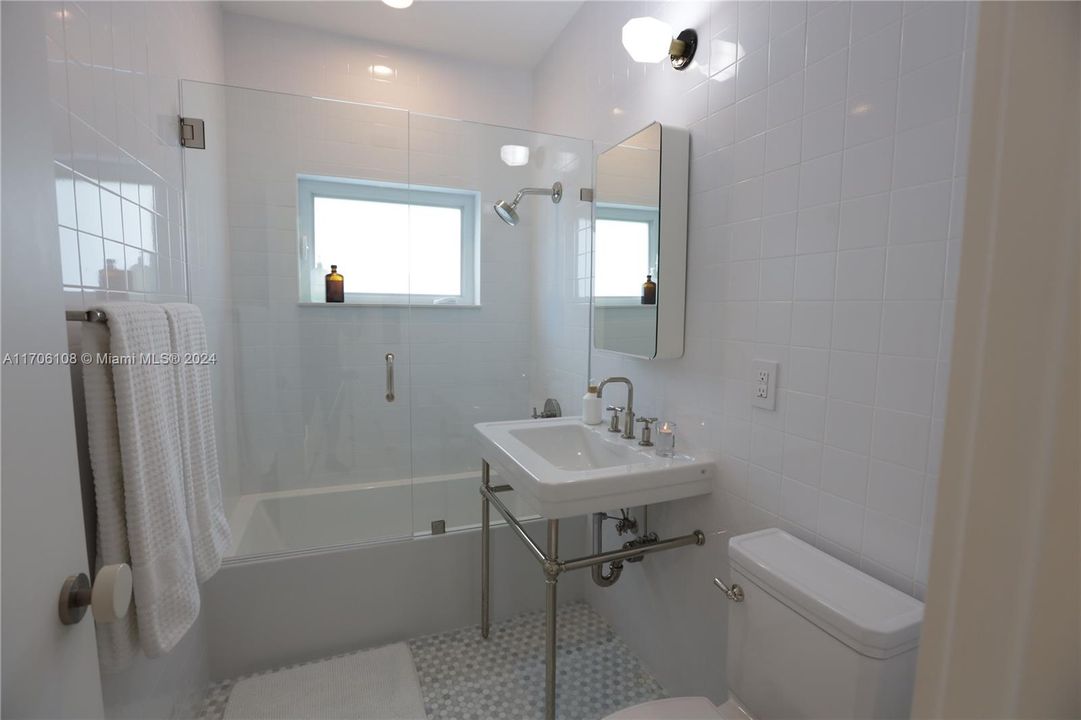 Guest bath with marble floors and European tub/shower combo.