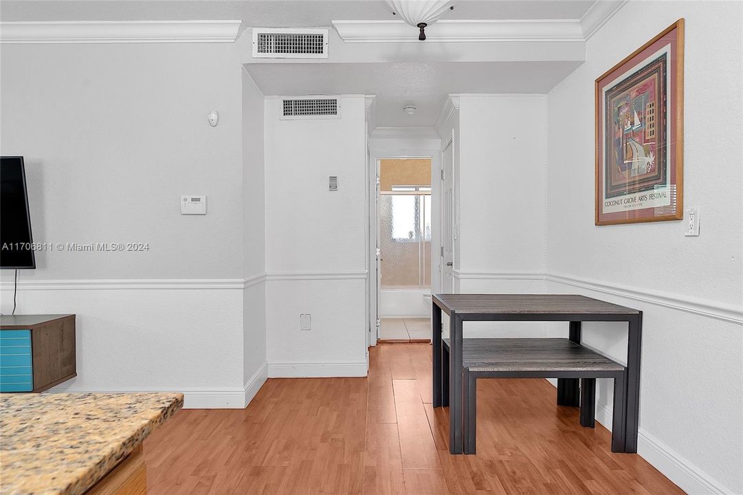 View of dining area with bathroom in the background and bedroom to the left.